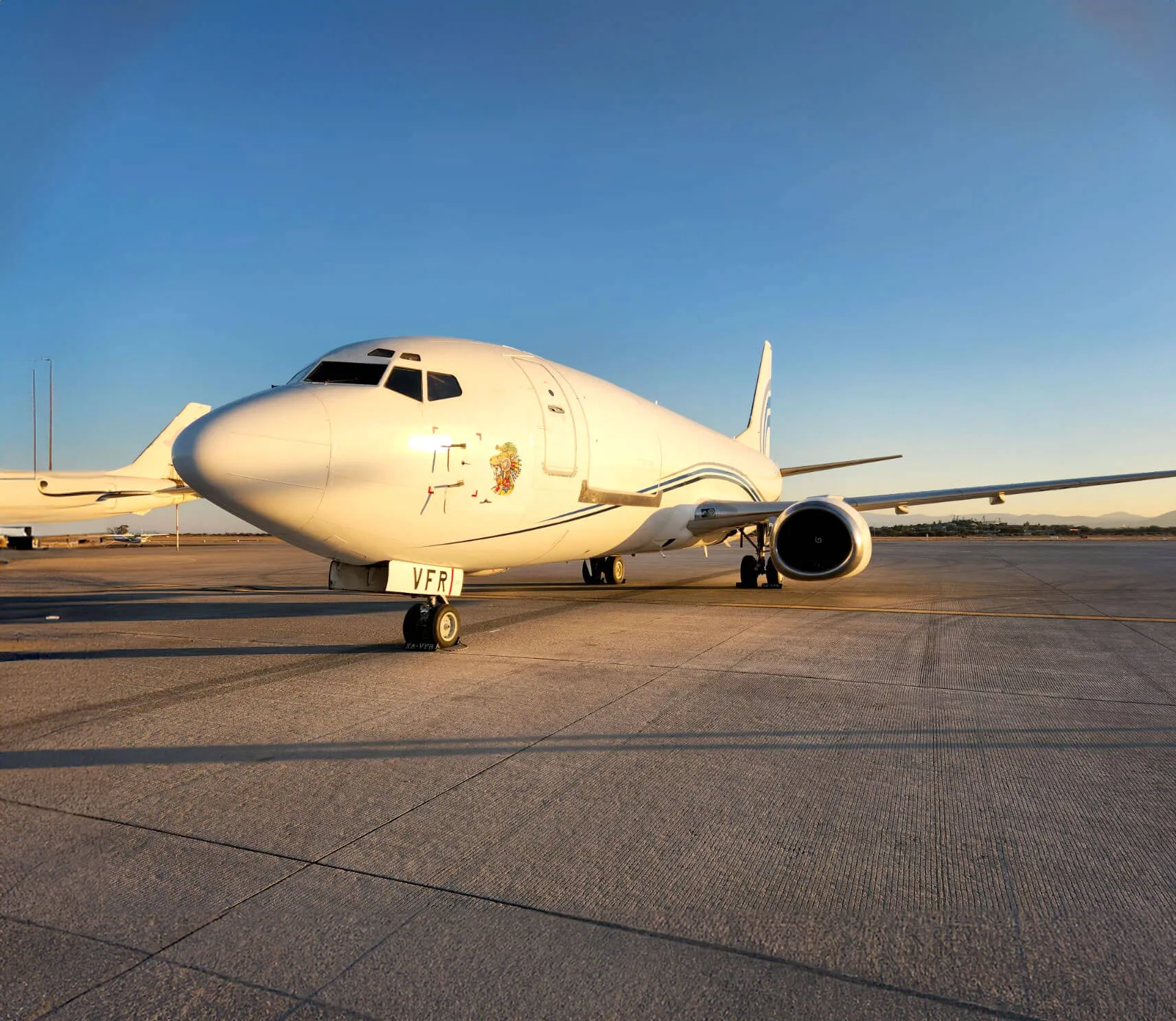 Boeing 737 - 300 SF en pista, con un atardecer.