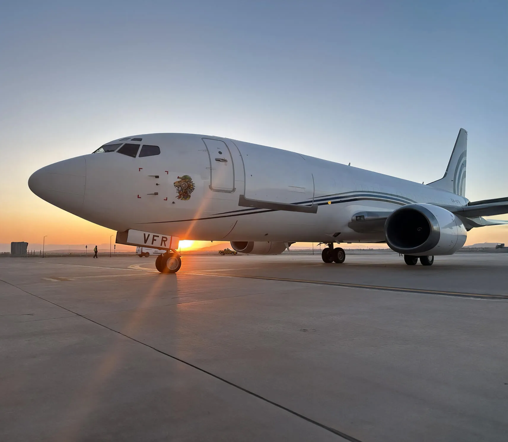 Imagen de un Boeing 737 - 300 SF a contra luz en un atardecer.